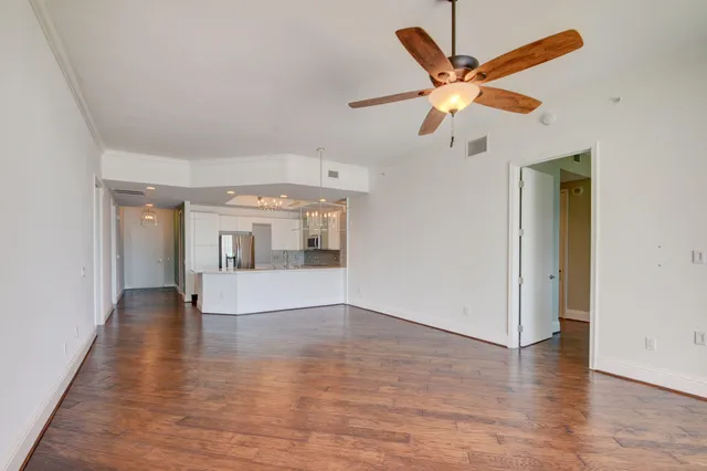 a view of a room with wooden floor chandelier and a window