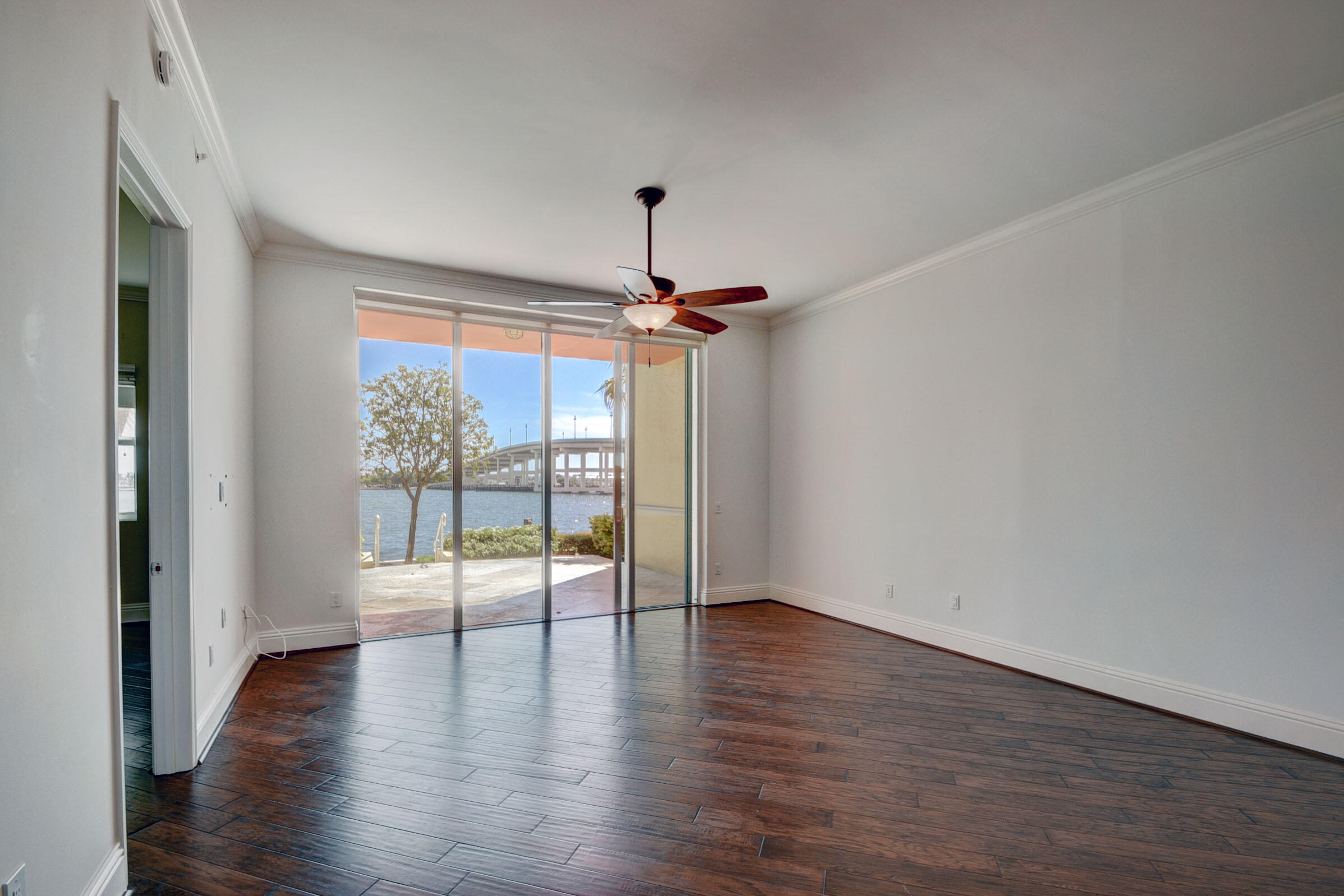 2640 Lake Shore Drive, Unit 115 Riviera Beach, FL 33404 - Photo 10 of 59 a view of an empty room with wooden floor and a window