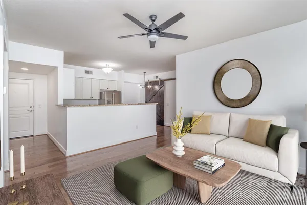 a living room with furniture and kitchen view