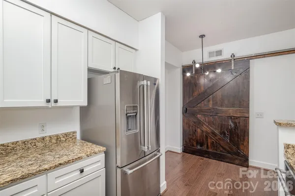 a kitchen with white cabinets and stainless steel appliances