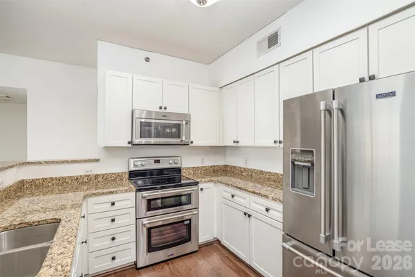 a kitchen with granite countertop a sink and a stove top oven