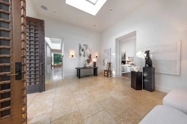 a view of a hallway with a chandelier and glass door