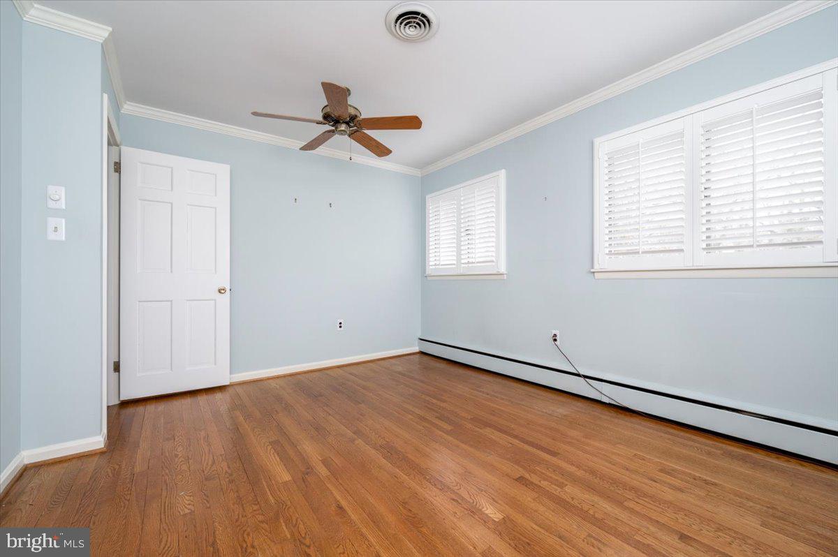 162 Sillery Bay Road Pasadena, MD 21122 - Photo 27 of 41 an empty room with wooden floor fan and windows