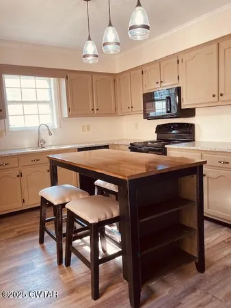 a kitchen with a table chairs microwave and cabinets
