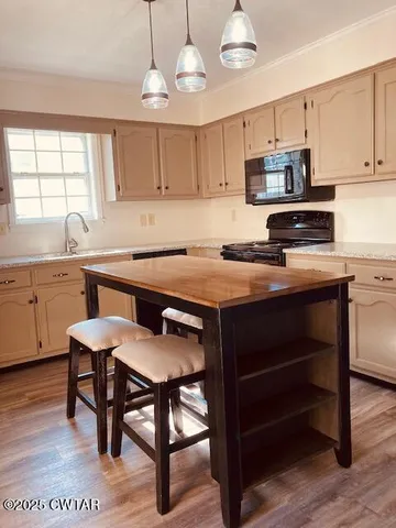 a kitchen with a table chairs microwave and cabinets