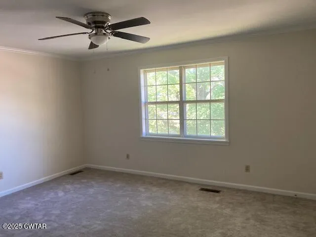 an empty room with a window and a fan