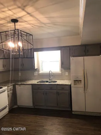 a kitchen with stainless steel appliances granite countertop a sink a stove and a refrigerator
