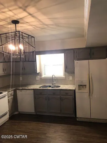 a kitchen with stainless steel appliances granite countertop a sink a stove and a refrigerator