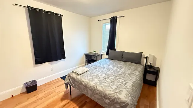 a bedroom with a bed and a flat tv screen on a dresser