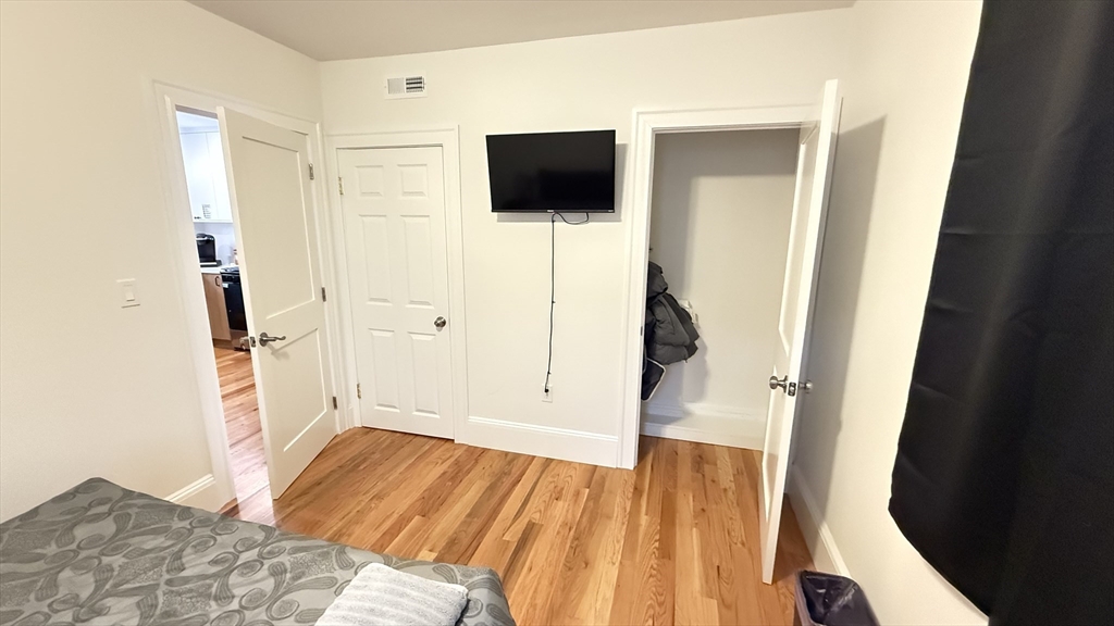 174 Boston Street, Unit 2 Boston, MA 02125 - Photo 4 of 8 a view of a livingroom with wooden floor and a flat screen tv