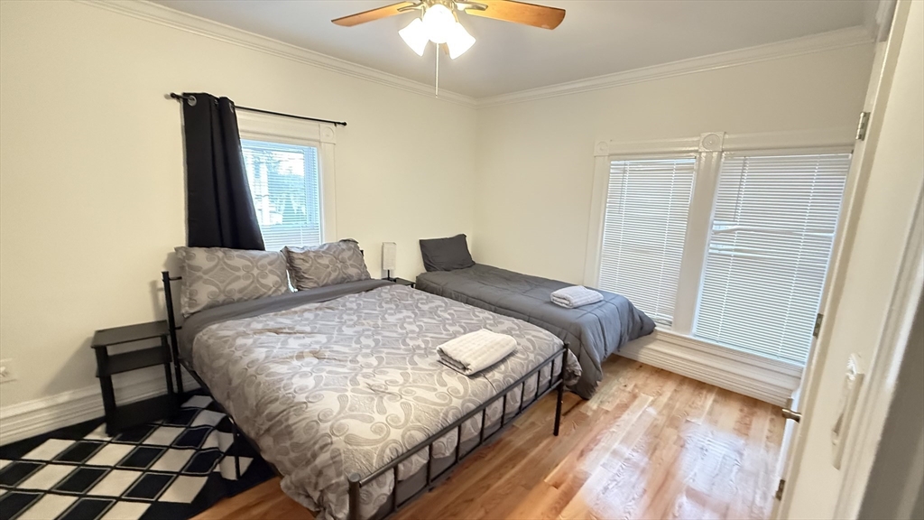 174 Boston Street, Unit 2 Boston, MA 02125 - Photo 5 of 8 a bedroom with a bed and a chandelier