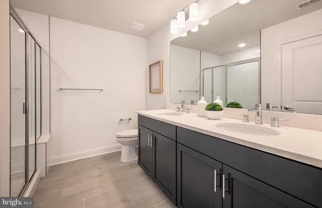 a bathroom with a double vanity sink mirror and toilet