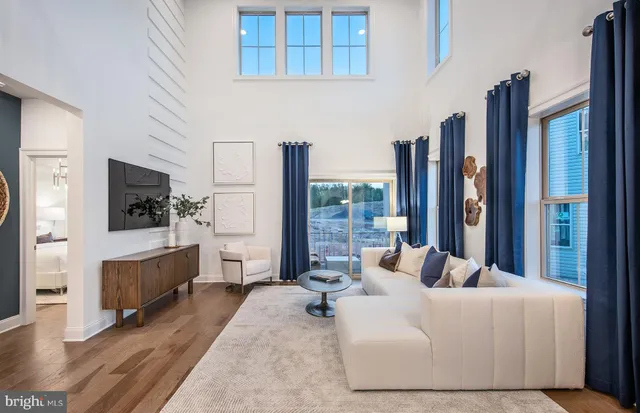 a living room with furniture a large window a flat screen tv and a large window