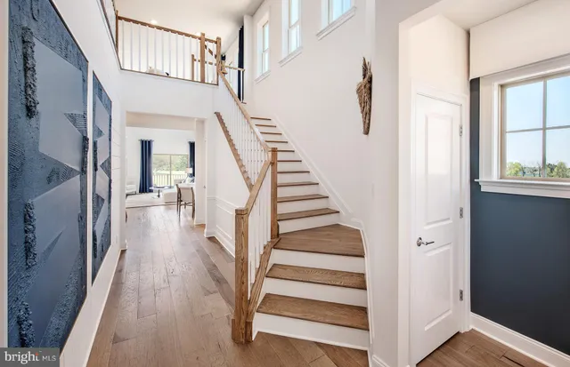 a view of staircase with lots of frames on wall and wooden floor