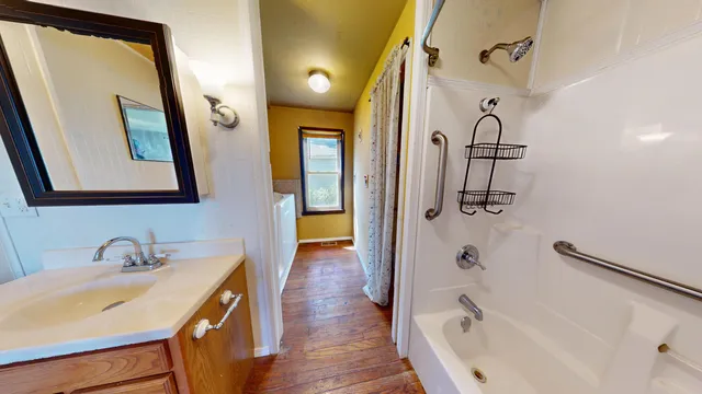 a bathroom with a tub sink and mirror