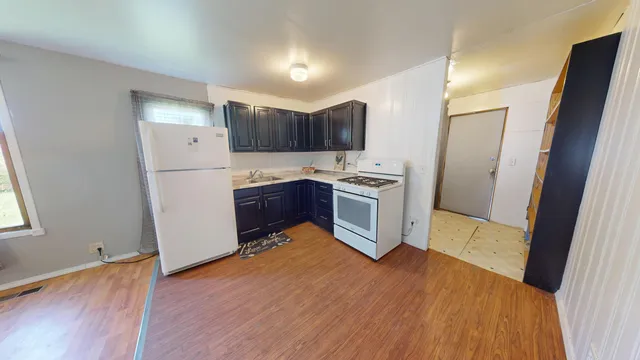 a kitchen with stainless steel appliances a refrigerator and wooden floor