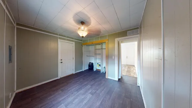 a view of an empty room with wooden floor