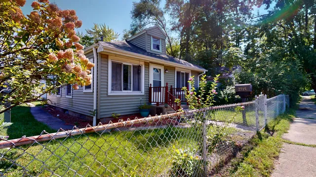 a view of house with a yard and potted plants