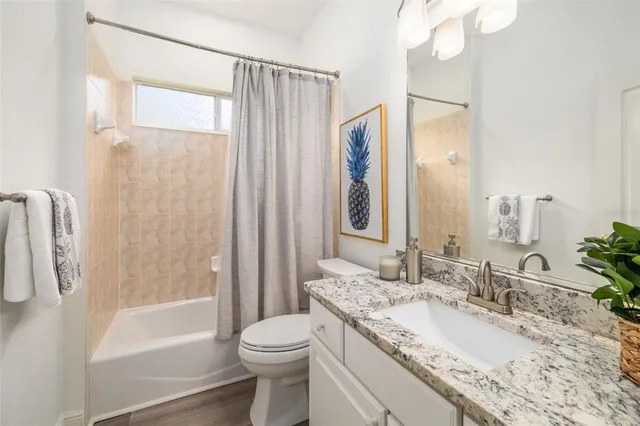a view of a room with wooden floor and a potted plant