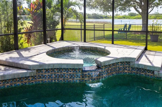 a view of a swimming pool with a chairs and tables in the patio