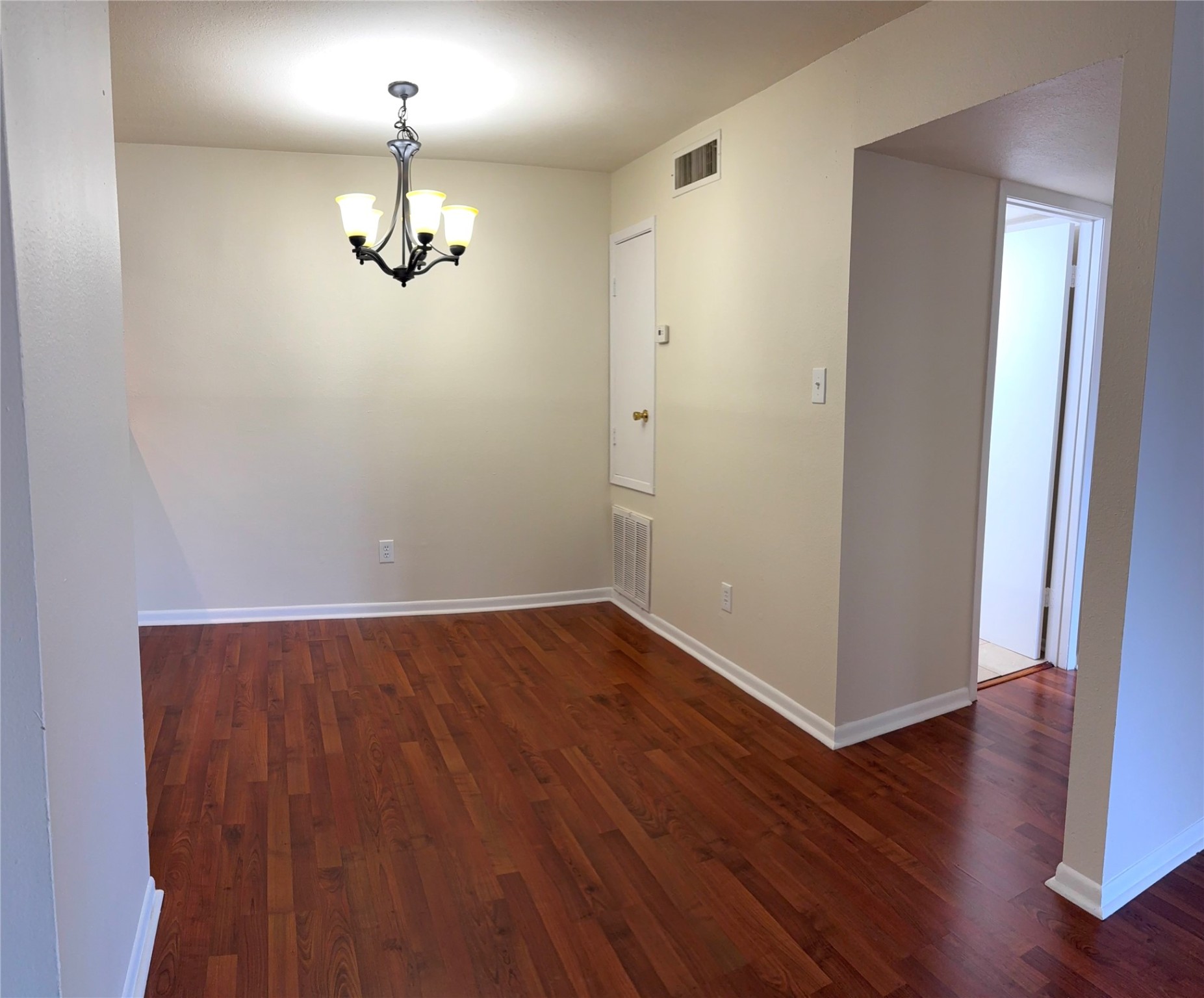17331 Red Oak Drive, Unit 38 Houston, TX 77090 - Photo 7 of 19 an empty room with wooden floor chandelier and windows