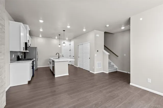 a view of kitchen with kitchen island white cabinets and stainless steel appliances