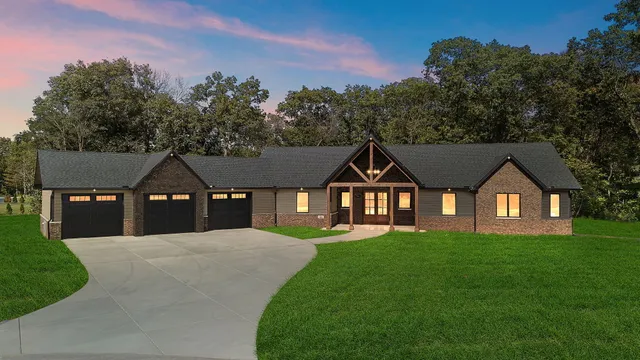 a front view of a house with a yard and trees