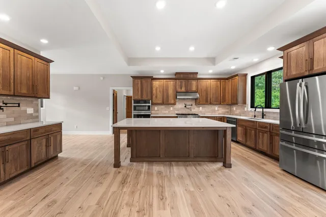 a kitchen with stainless steel appliances granite countertop a stove microwave and cabinets