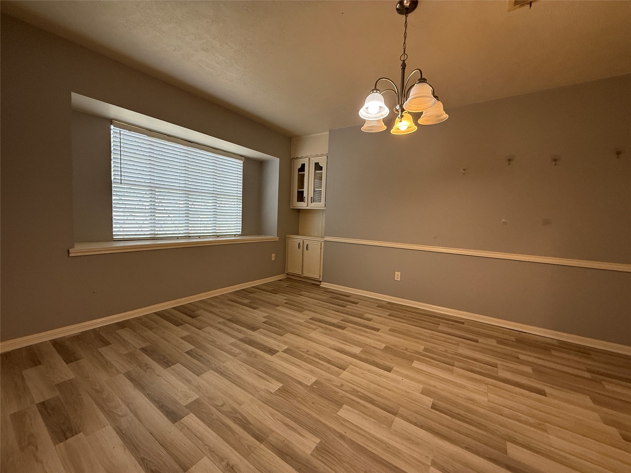 422 Gamewood Drive Spring, TX 77386 - Photo 19 of 25 a view of an empty room with chandelier and wooden floor