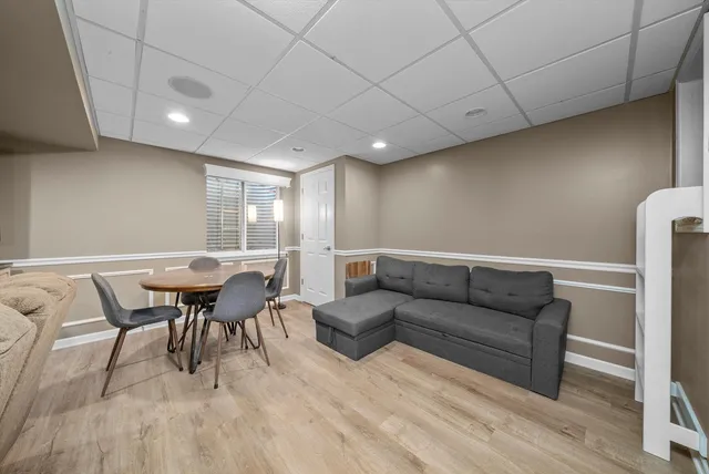 a living room with furniture a dining table and a wooden floor