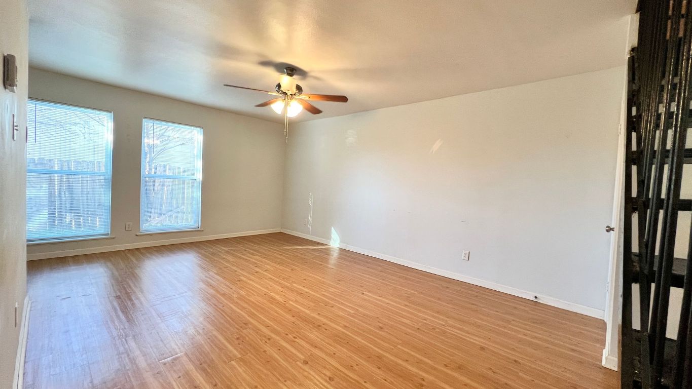 2301 Ohlen Road, Unit 103 Austin, TX 78757 - Photo 4 of 12 Spare room featuring light wood finished floors, ceiling fan, and stairs