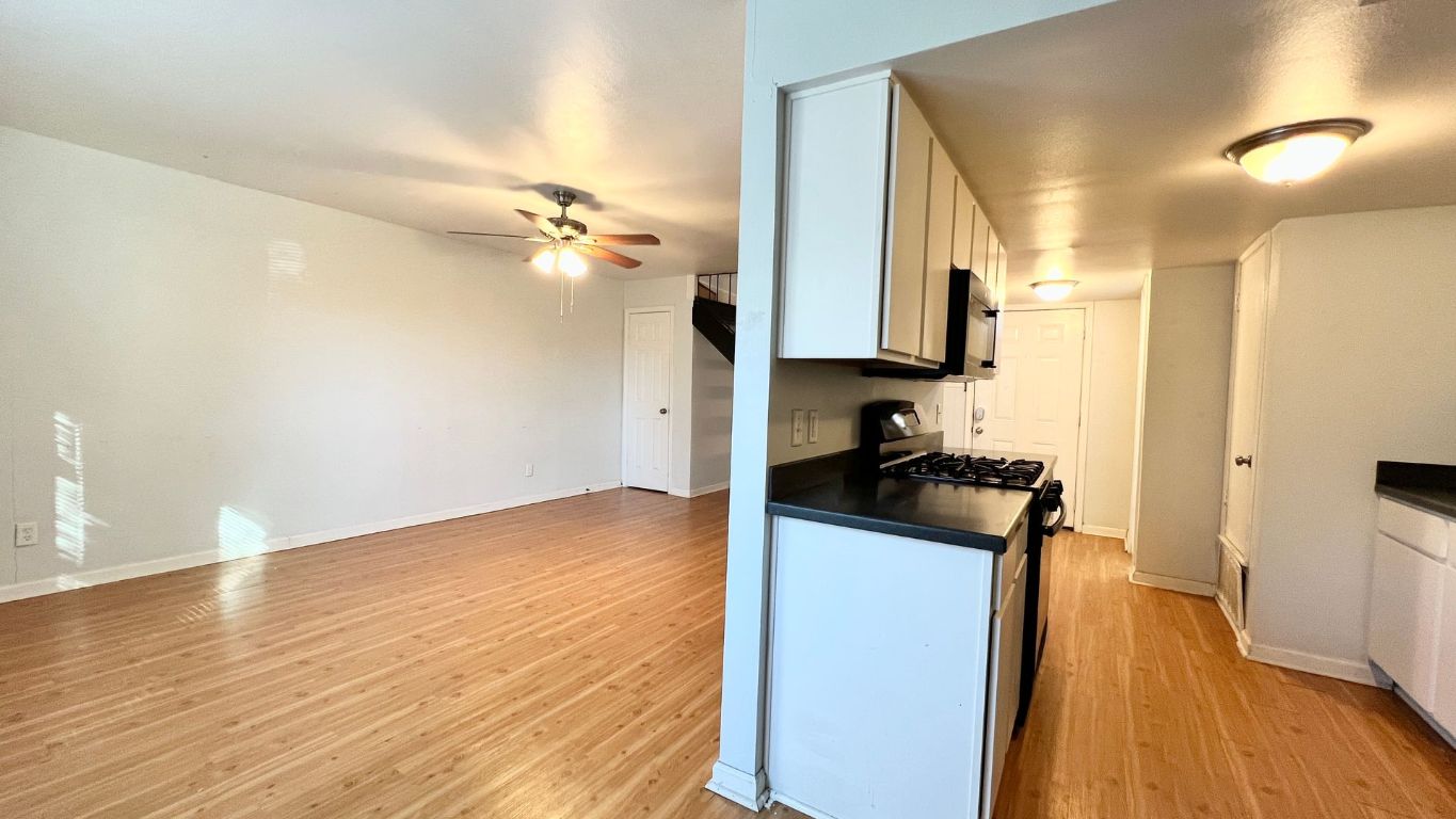 2301 Ohlen Road, Unit 103 Austin, TX 78757 - Photo 5 of 12 Kitchen with dark countertops, gas range, white cabinetry, and light wood-style flooring