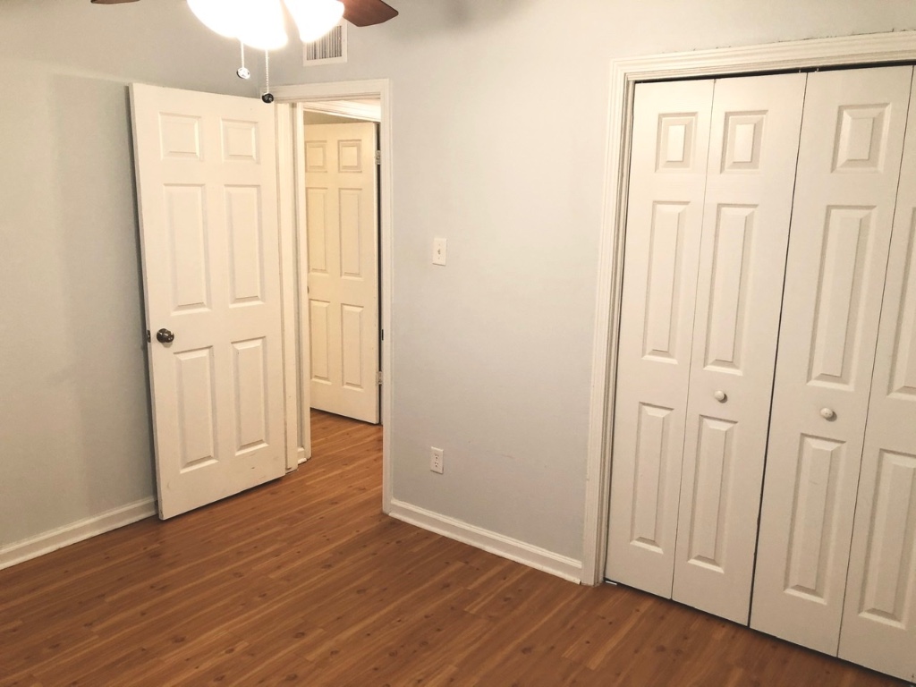 2301 Ohlen Road, Unit 213 Austin, TX 78757 - Photo 8 of 12 Unfurnished bedroom with a closet, a ceiling fan, and dark wood-style flooring
