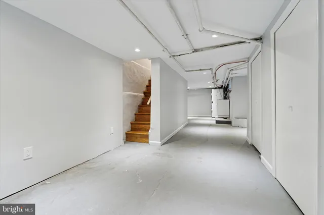 a view of empty room with staircase and a white door