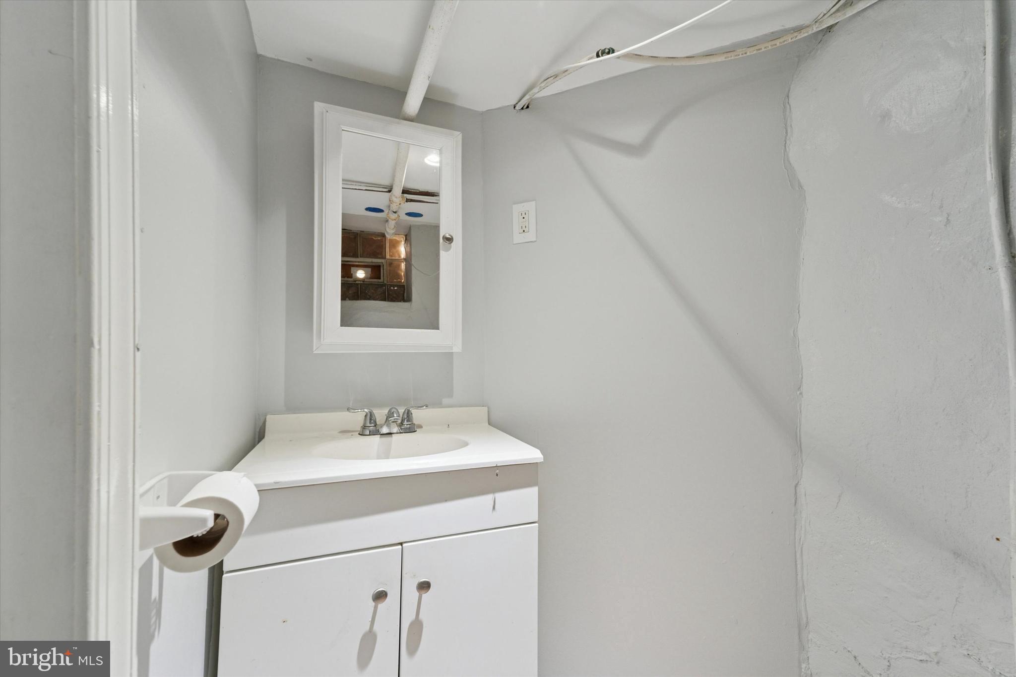 3052 Aramingo Avenue Philadelphia, PA 19134 - Photo 22 of 24 a bathroom with a sink and a mirror