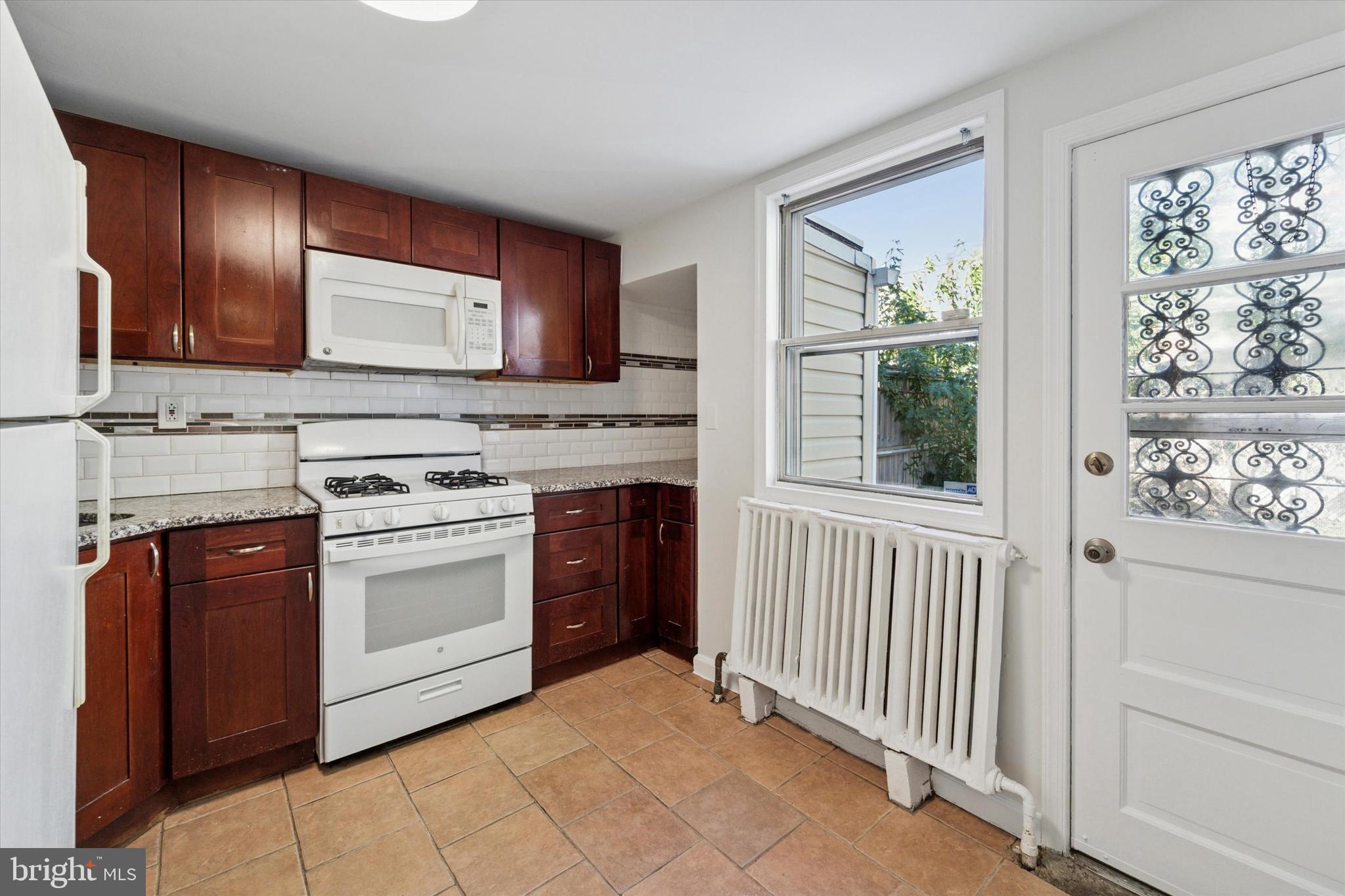 3052 Aramingo Avenue Philadelphia, PA 19134 - Photo 10 of 24 a kitchen with stainless steel appliances granite countertop a stove top oven sink and cabinets