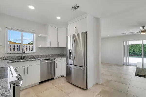 a kitchen with stainless steel appliances granite countertop a refrigerator and a sink