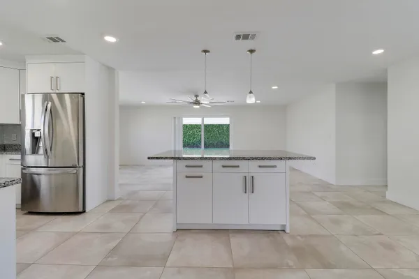 a kitchen with stainless steel appliances granite countertop a refrigerator and a sink