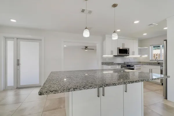 a kitchen with stainless steel appliances granite countertop a sink a stove and a granite counter tops