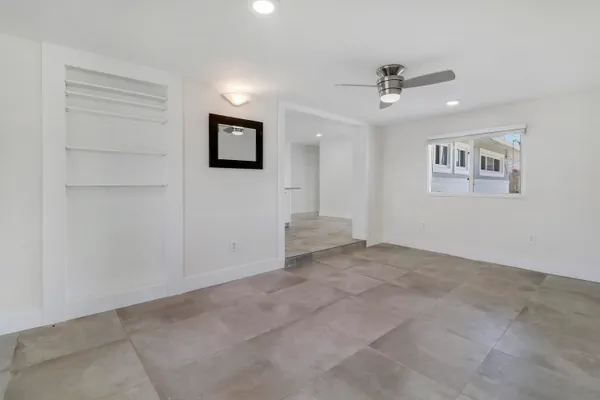a view of a livingroom with a ceiling fan & windows