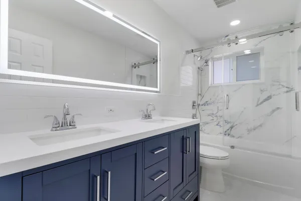 a bathroom with a granite countertop sink a toilet and a bathtub