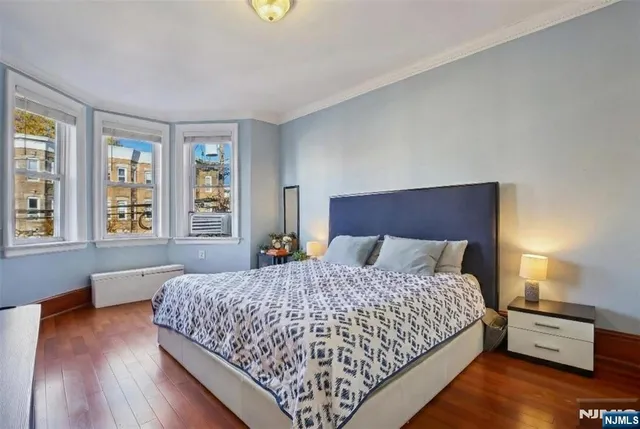 a bedroom with a bed and wooden floor
