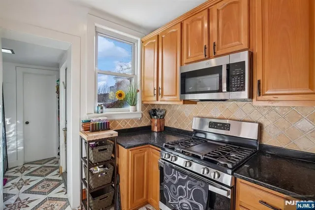 a kitchen with stainless steel appliances a stove a sink and a microwave
