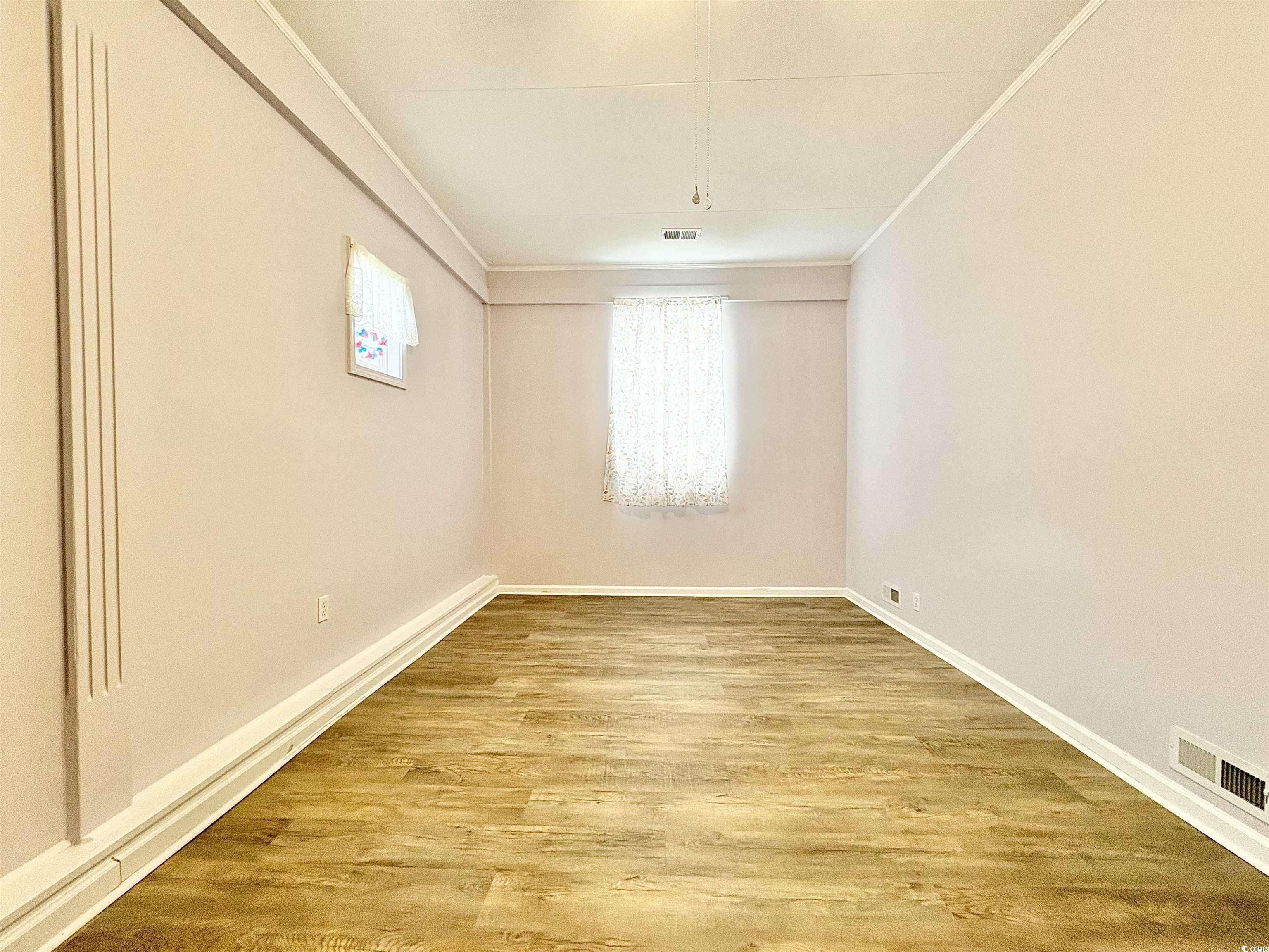 703 62nd Avenue North Myrtle Beach, SC 29577 - Photo 14 of 20 Empty room with light wood-style flooring and crown molding