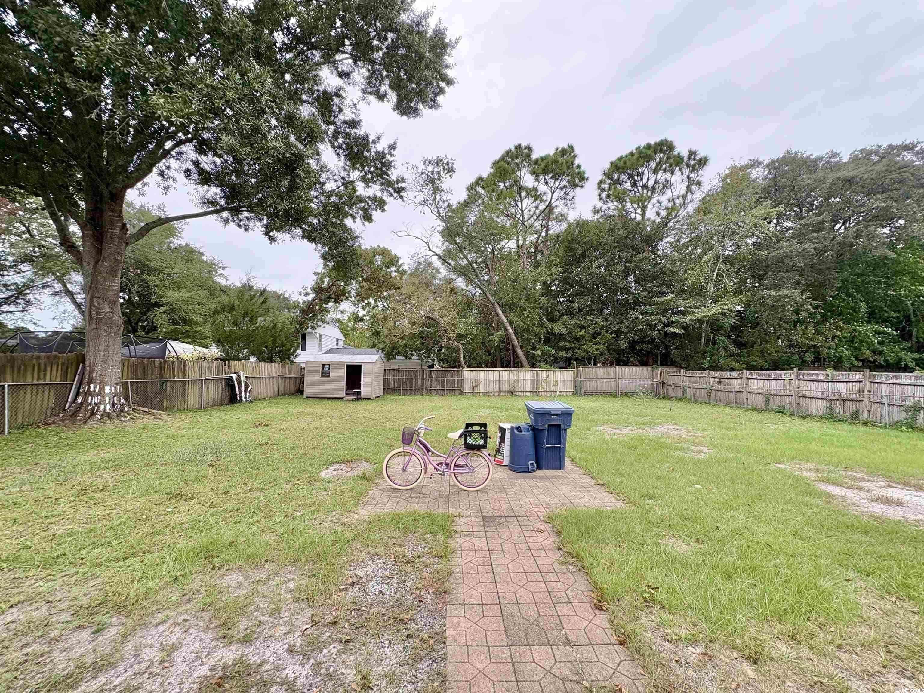 703 62nd Avenue North Myrtle Beach, SC 29577 - Photo 17 of 20 Fenced backyard with a patio area and a shed