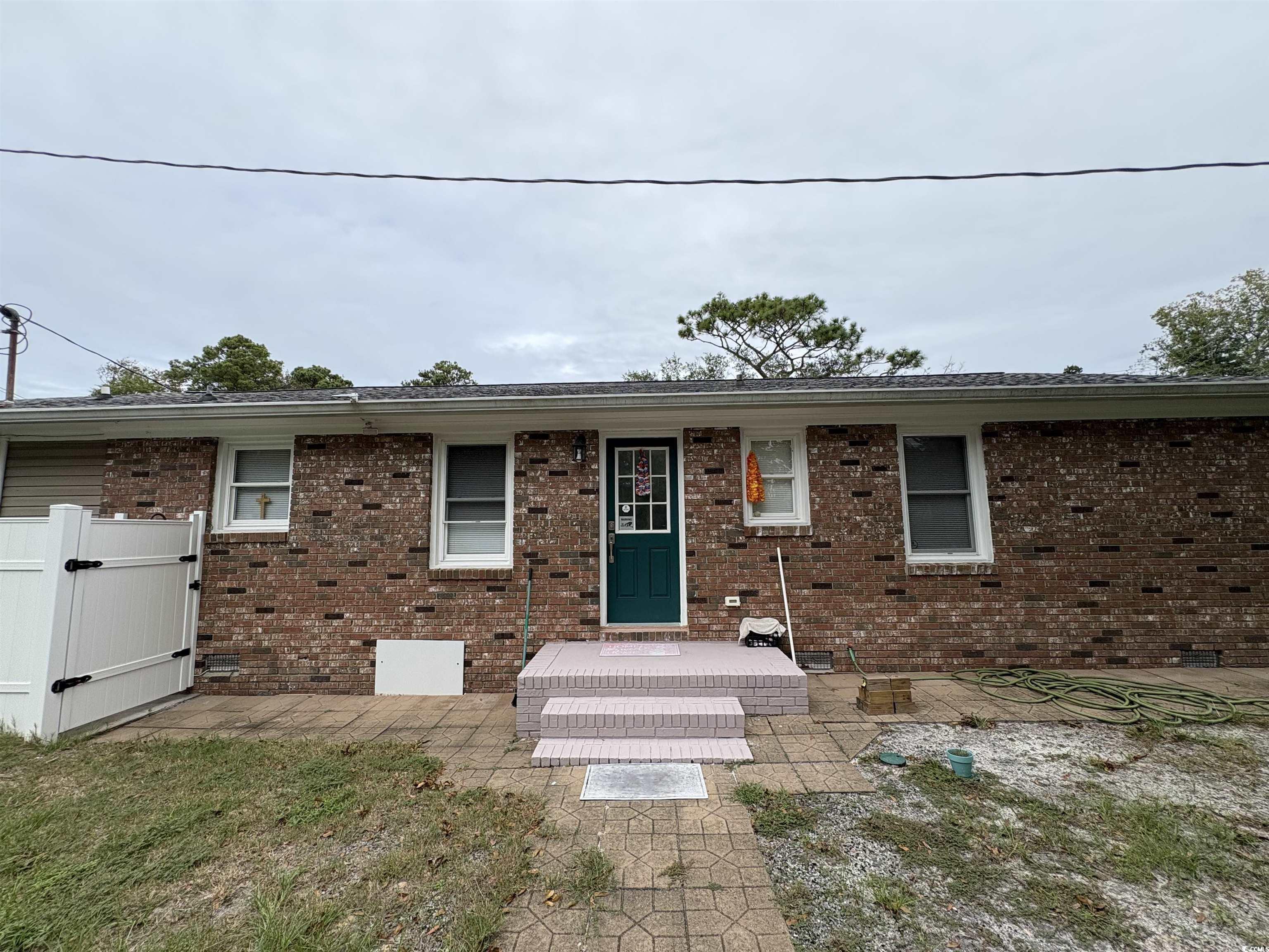 703 62nd Avenue North Myrtle Beach, SC 29577 - Photo 18 of 20 View of front of house with a patio area, brick siding, and a gate