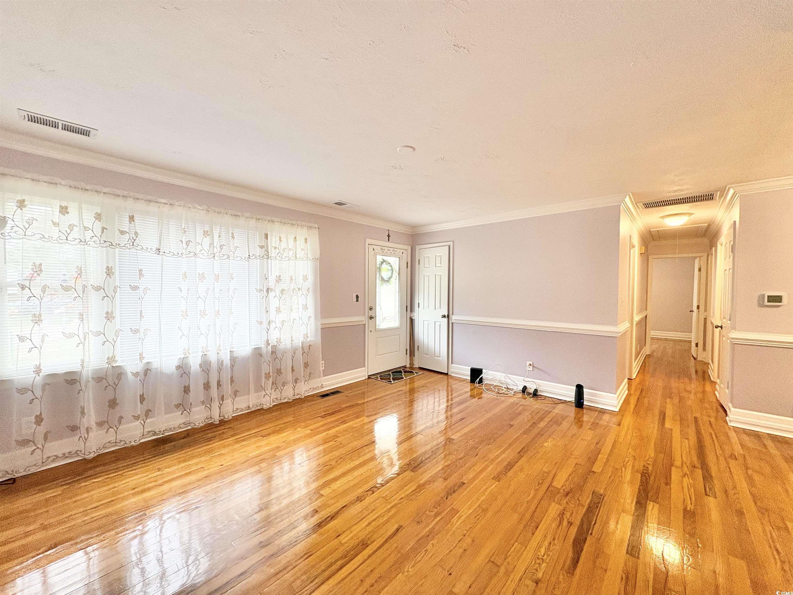 703 62nd Avenue North Myrtle Beach, SC 29577 - Photo 5 of 20 Empty room with light wood-type flooring and crown molding