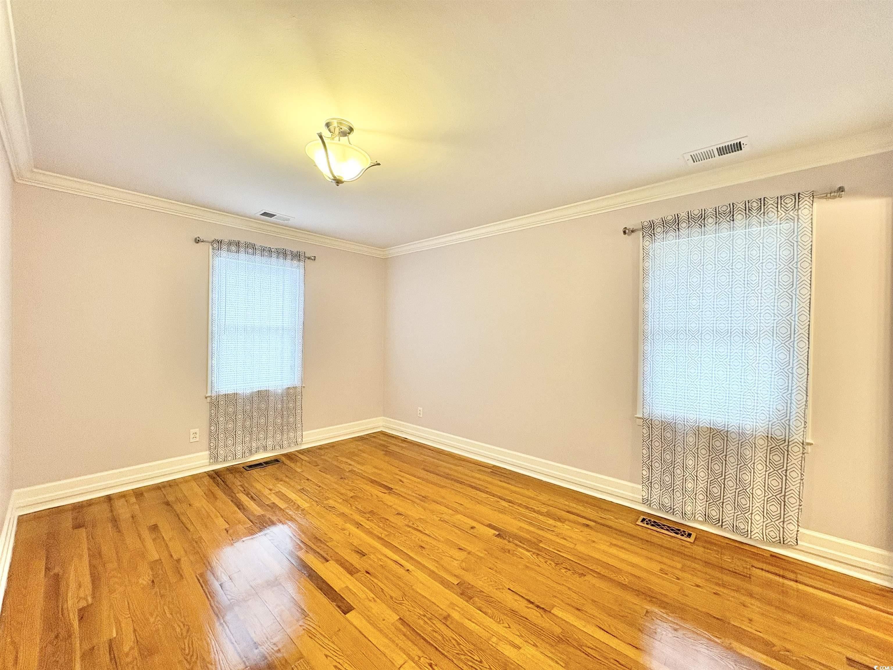 703 62nd Avenue North Myrtle Beach, SC 29577 - Photo 7 of 20 Unfurnished room with ornamental molding and light wood-style flooring