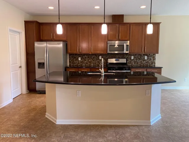 a kitchen with stainless steel appliances granite countertop a refrigerator and a stove