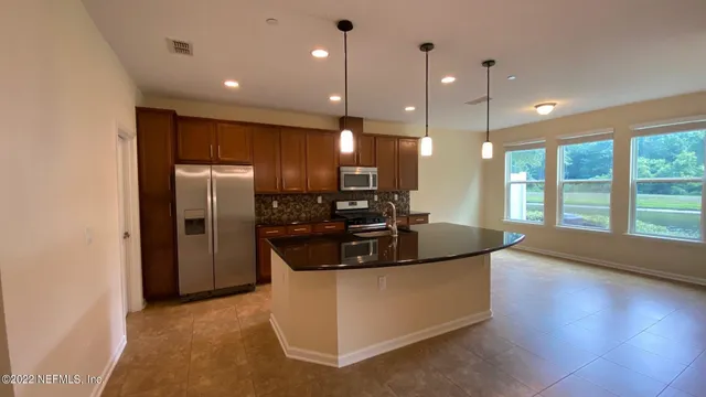 a kitchen with stainless steel appliances granite countertop a sink a stove and a refrigerator